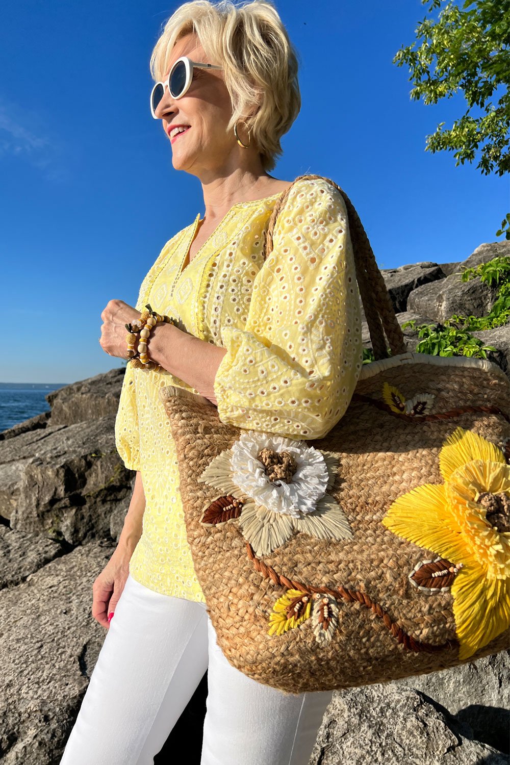 how to style a woven bag -straw bag with yellow eyelet top, white jeans
